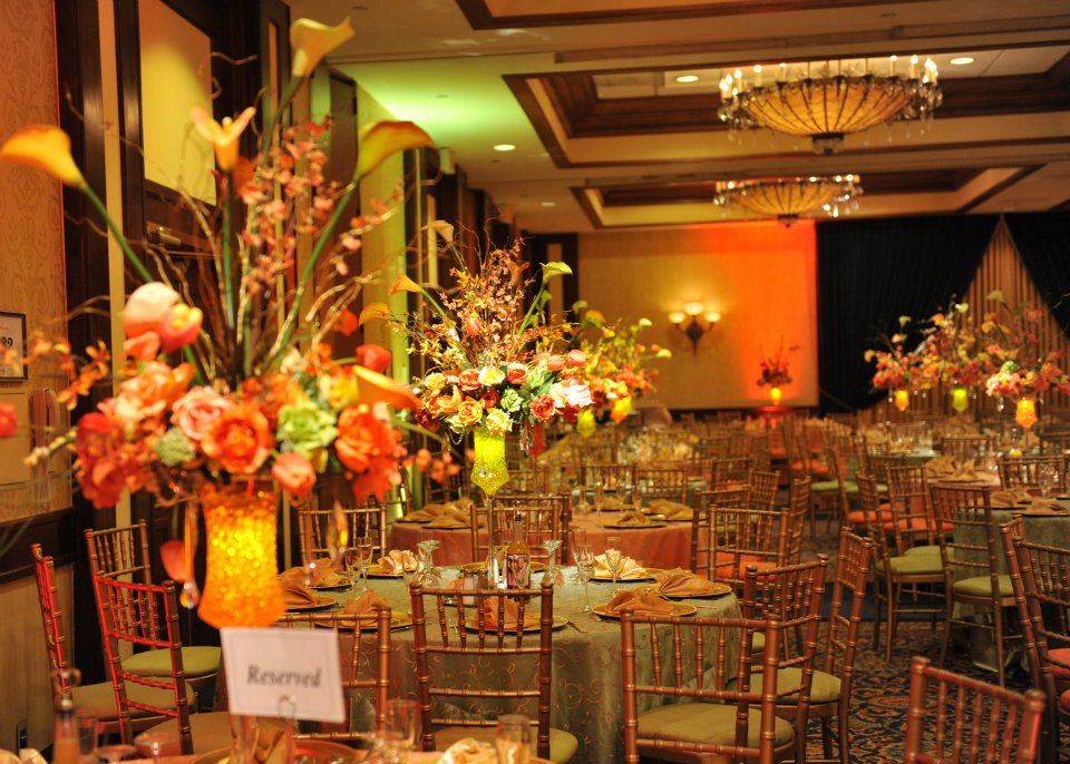 Elegant gold and champagne wedding reception table setting with floral centerpieces